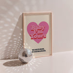 Baby I'm Yours poster in wood frame beside a disco ball, red heart with 'no returns no exchanges' caption on navy
