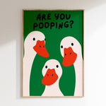 Framed artwork with cartoon ducks and text 'Are you pooping?' on a green background.