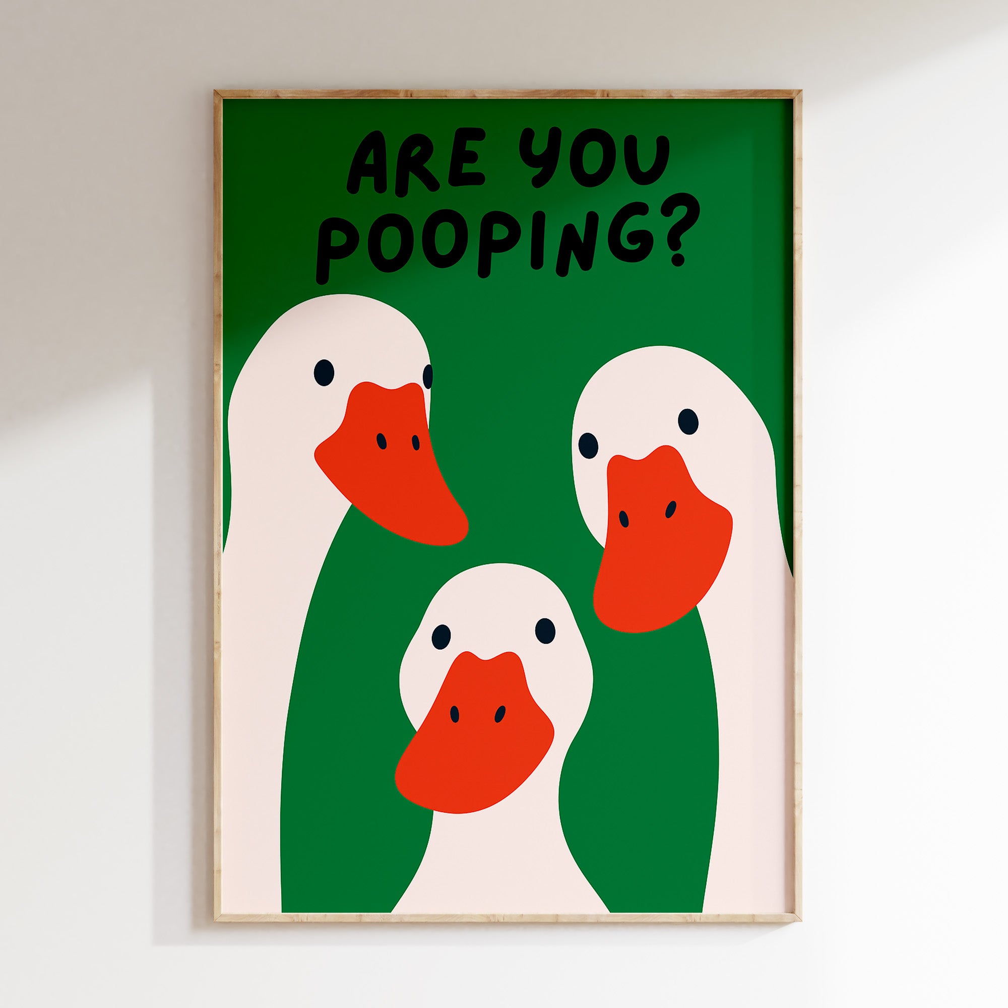 Framed artwork with cartoon ducks and text 'Are you pooping?' on a green background.