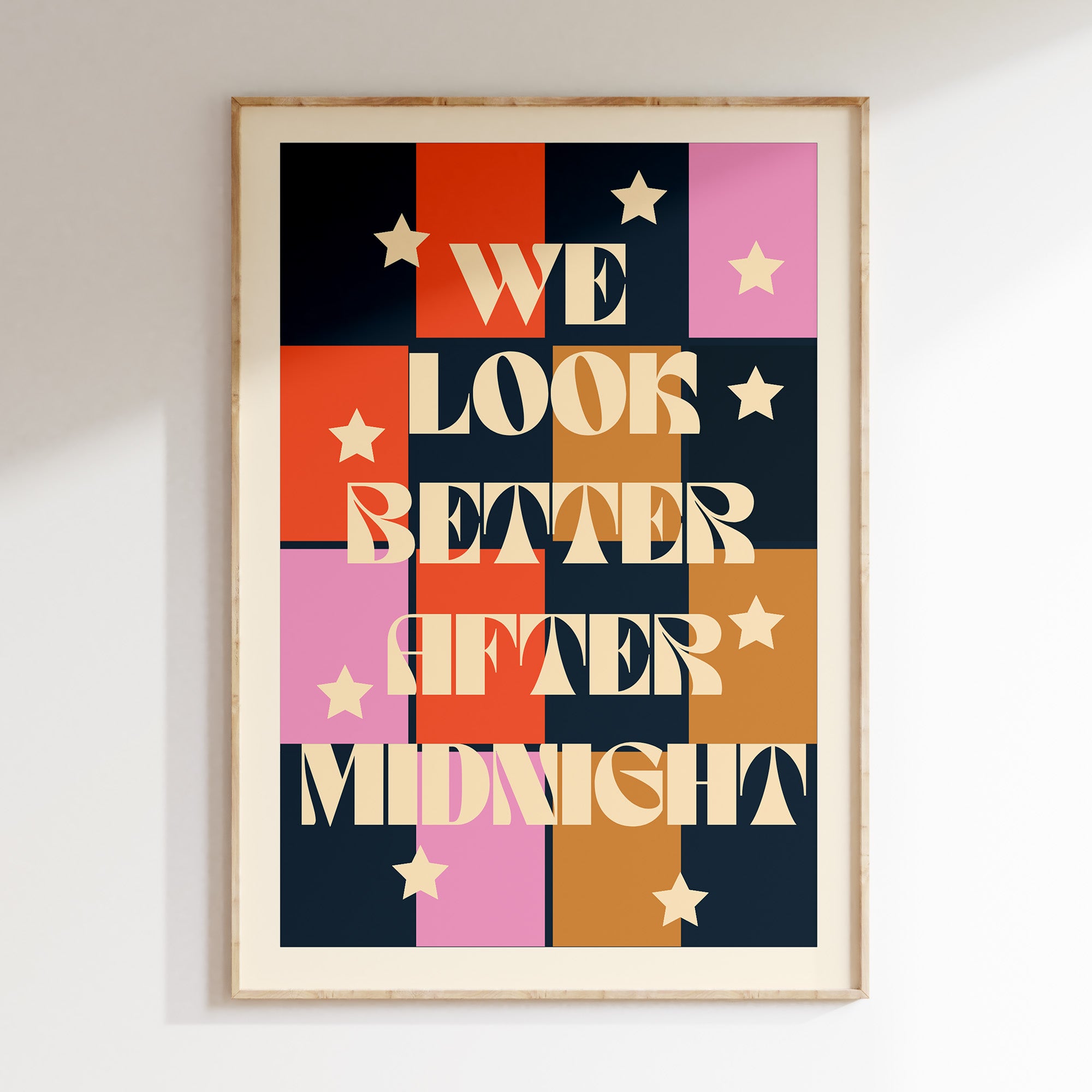 We Look Better After Midnight print in oak frame, colour-block grid in navy, red, pink and ochre with cream stars