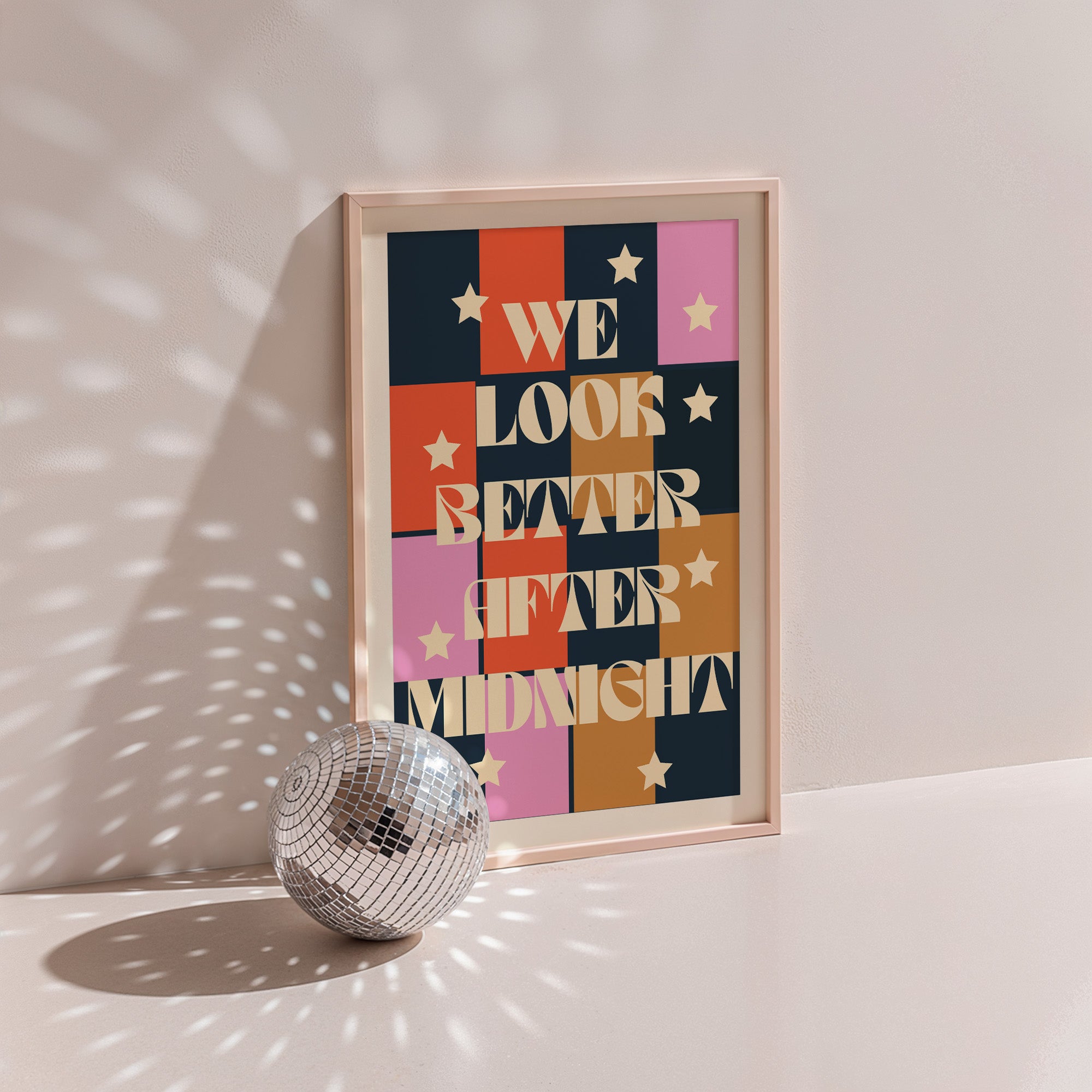 We Look Better After Midnight poster in wood frame beside a disco ball, colour-block grid with stars