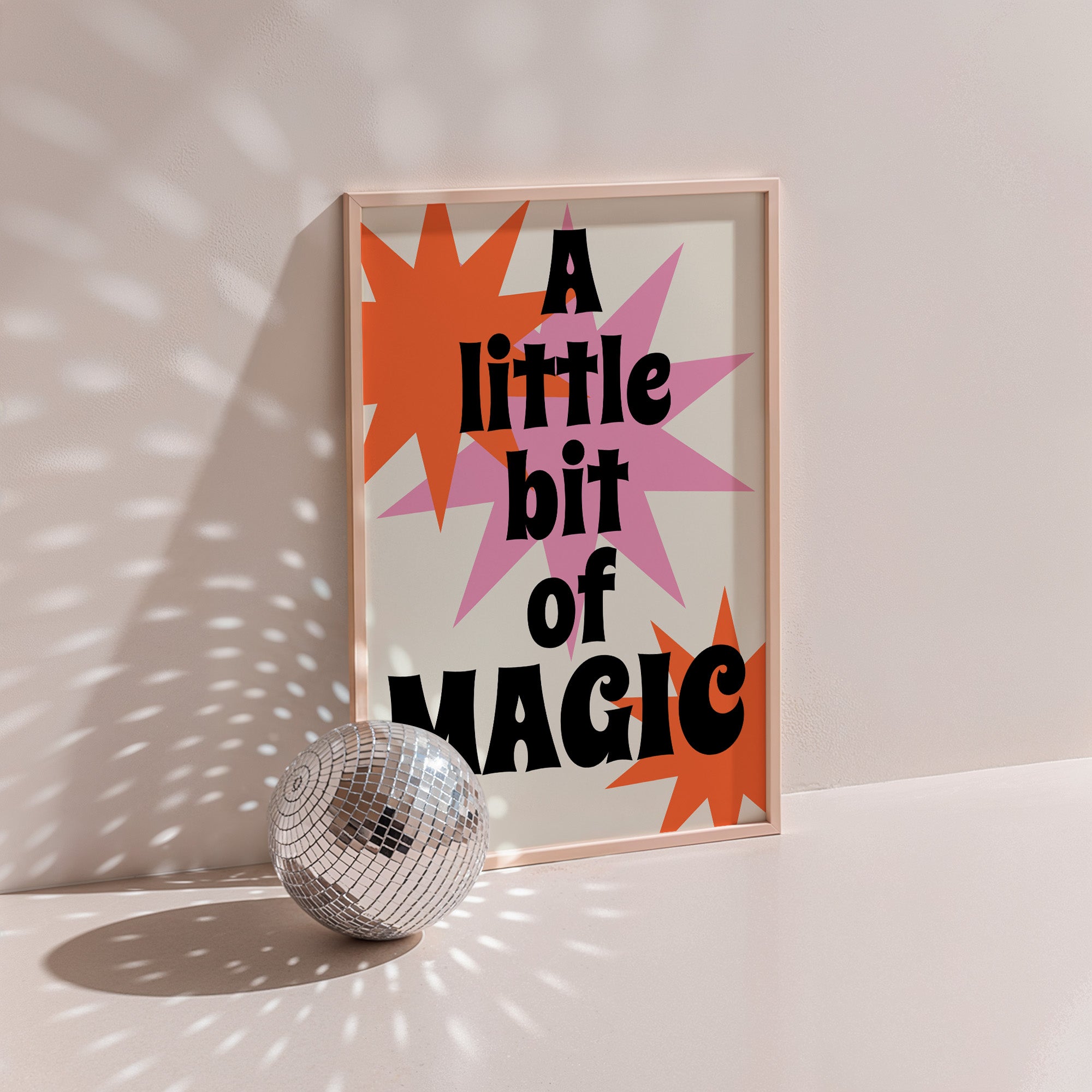A Little Bit Of Magic retro poster in wood frame with disco ball, orange and pink starbursts, bold black lettering