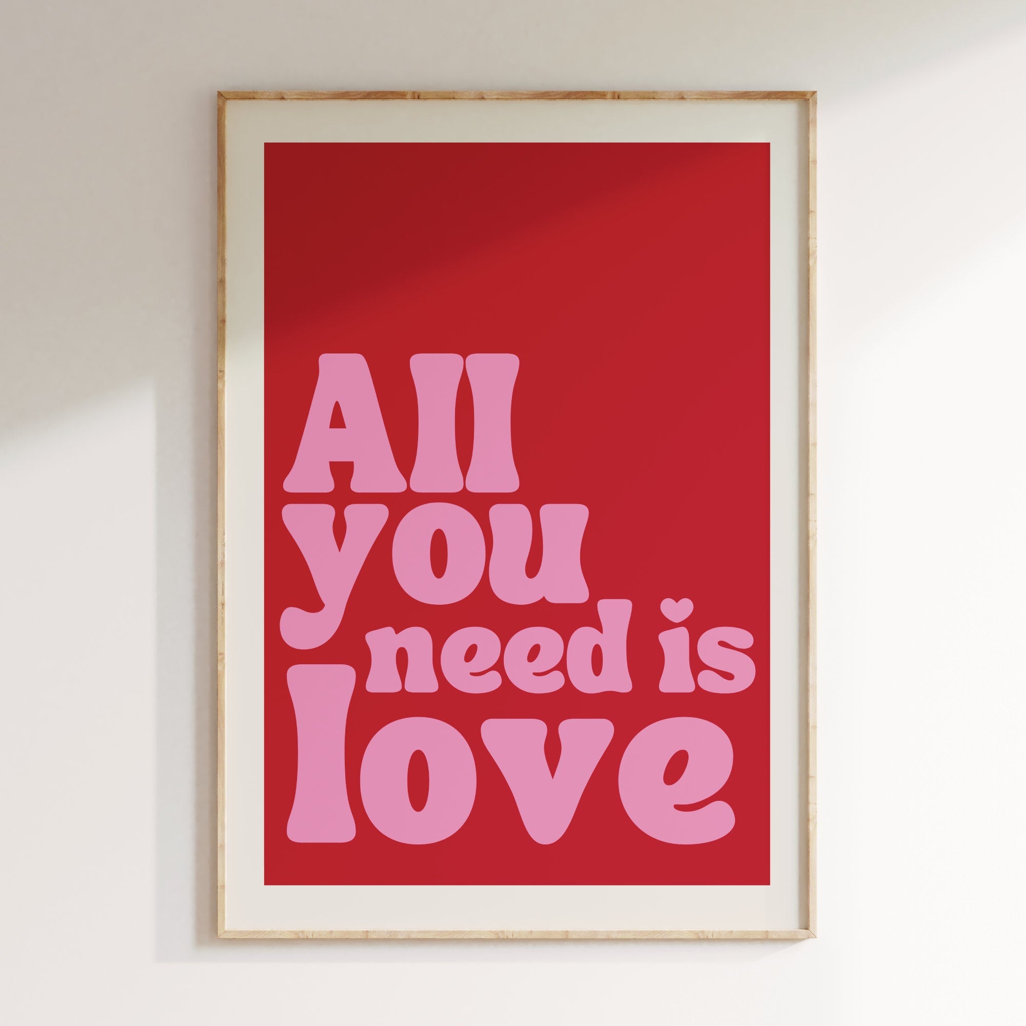 All You Need Is Love retro print in oak frame, red background with pink retro lettering
