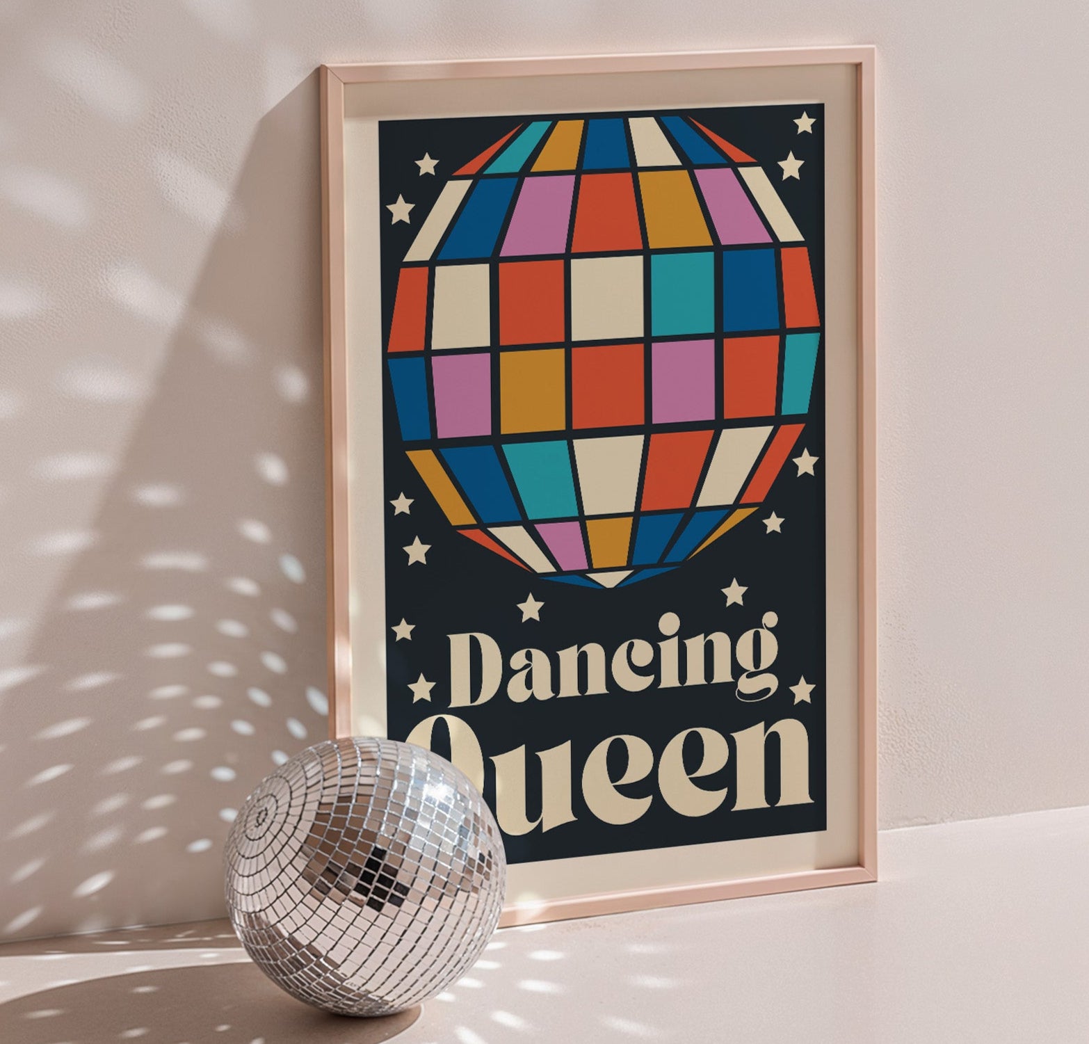 Dancing Queen poster in wood frame beside a disco ball, navy background with multicoloured disco ball
